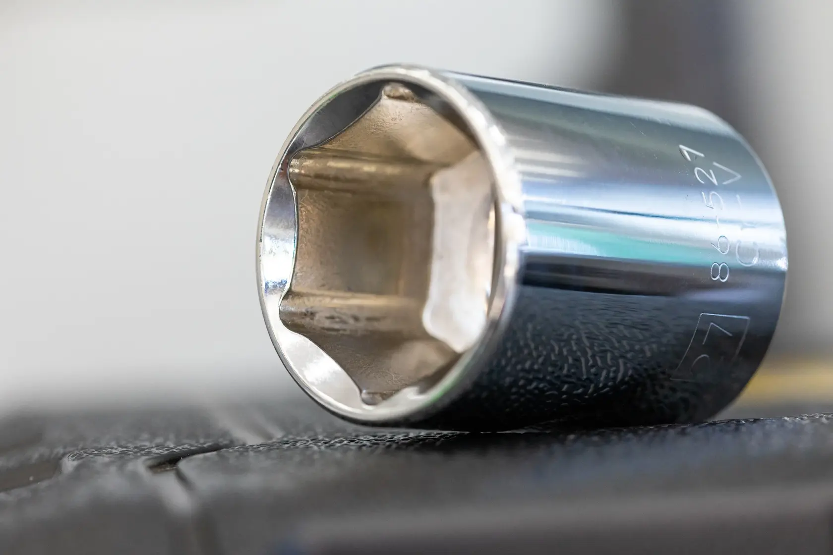STANLEY STMT82828-1 chrome socket, close-up side angle, photography of metal tool on dark surface.