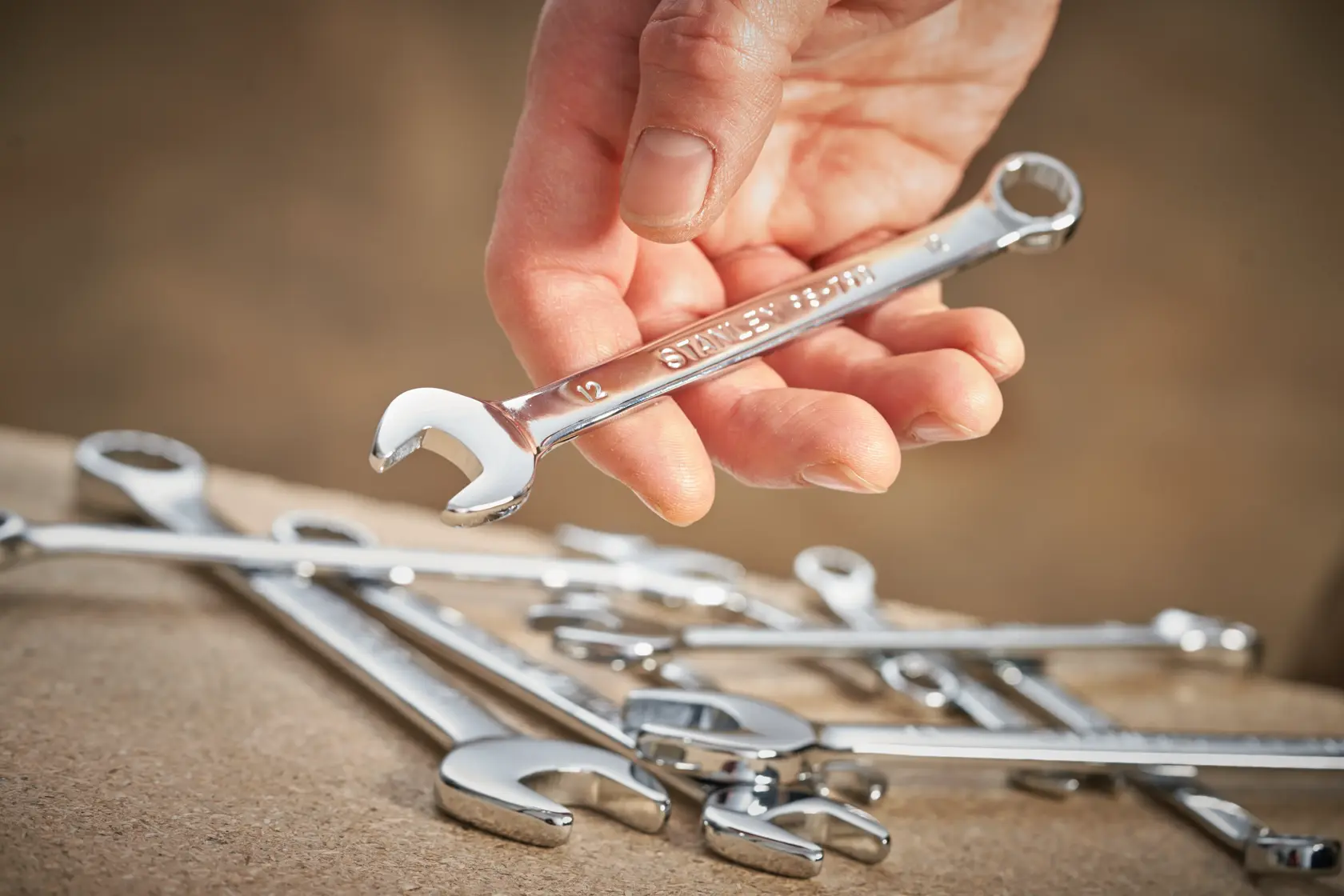 STANLEY STMT95788-0 chrome combination wrench set, close-up photography of hand holding single wrench.