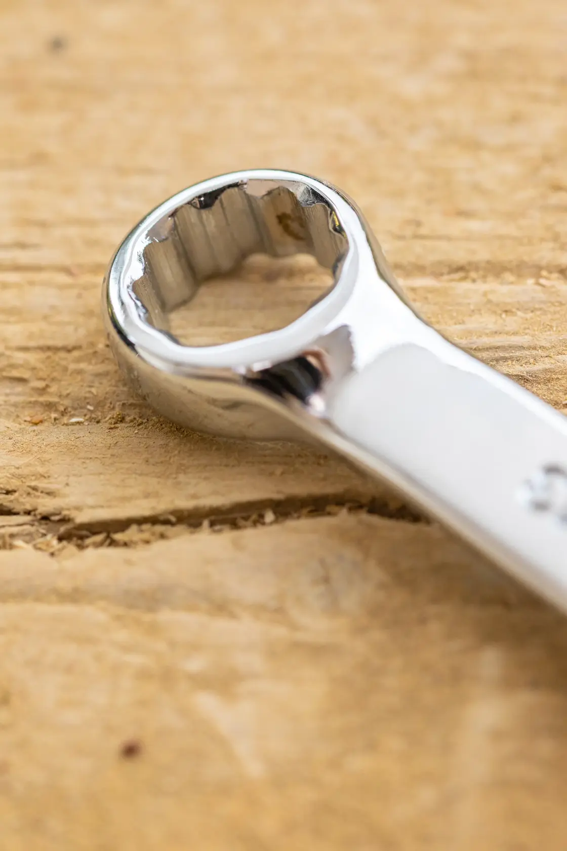 STANLEY STMT95788-0 close-up of chrome combination wrench ring end on wood surface.