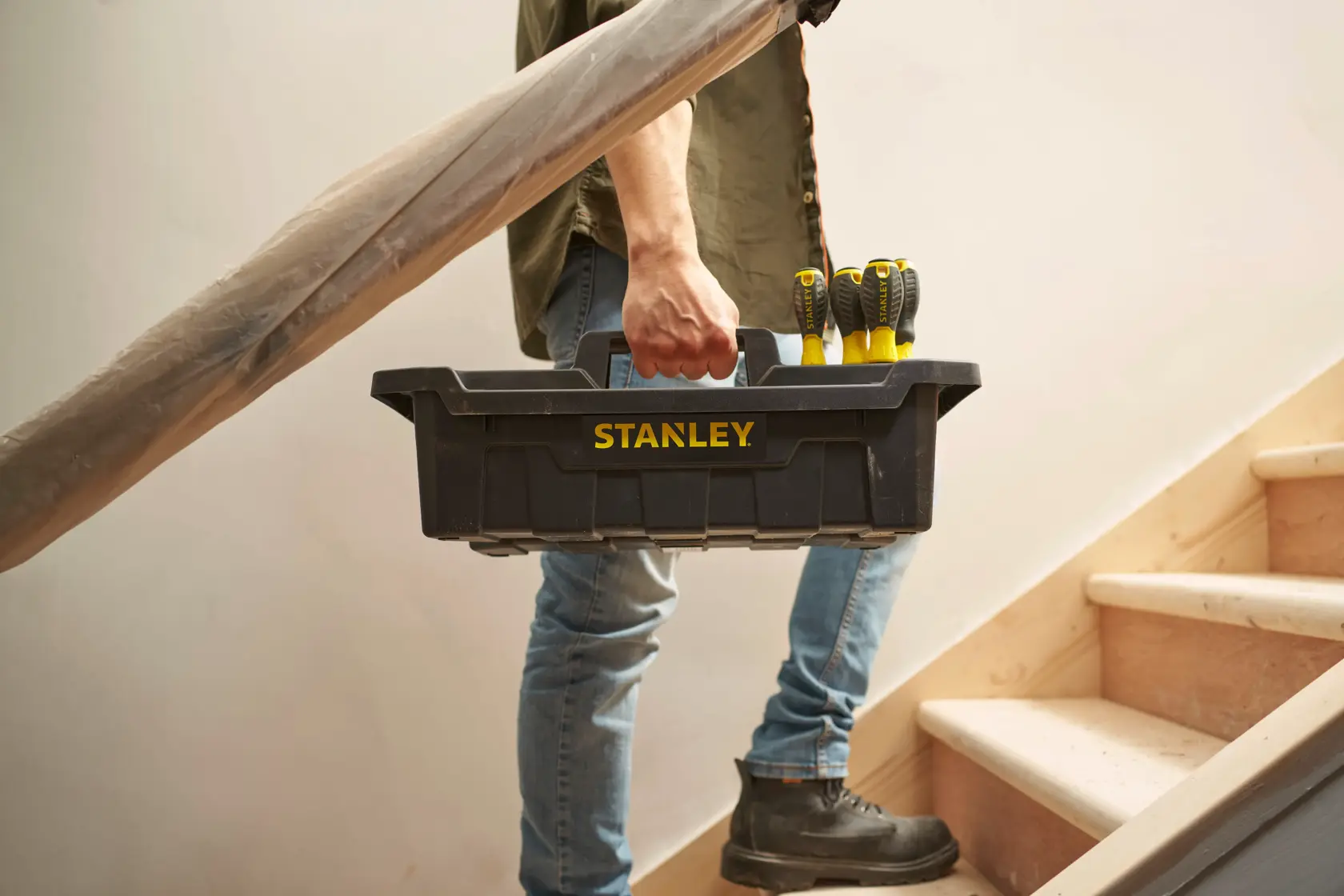 Stanley STST1-72359 black toolbox with screwdrivers, carried by person on stairs.