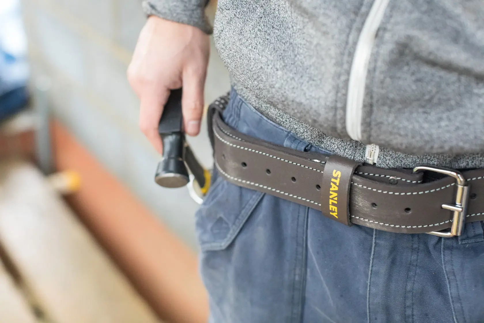 STANLEY STST1-80119 brown leather tool belt worn at waist, visible STANLEY logo, close-up side angle.