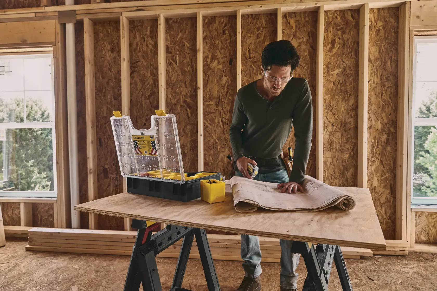 STANLEY STST14710 organizer open on worktable with clear lid and yellow compartments in construction setting.