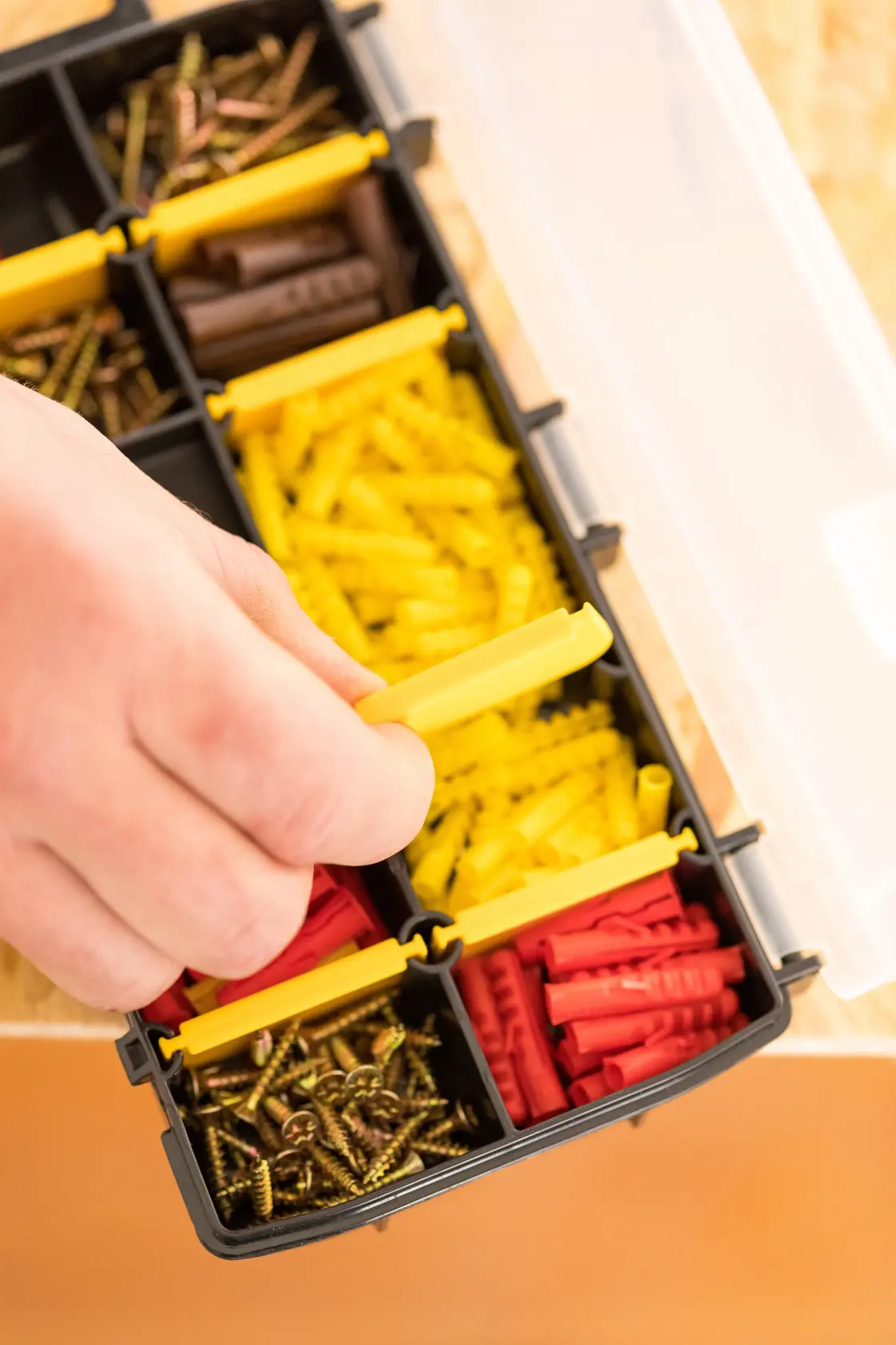 STANLEY STST81679-1 organizer with assorted screws and wall plugs, hand opening compartment, top view.