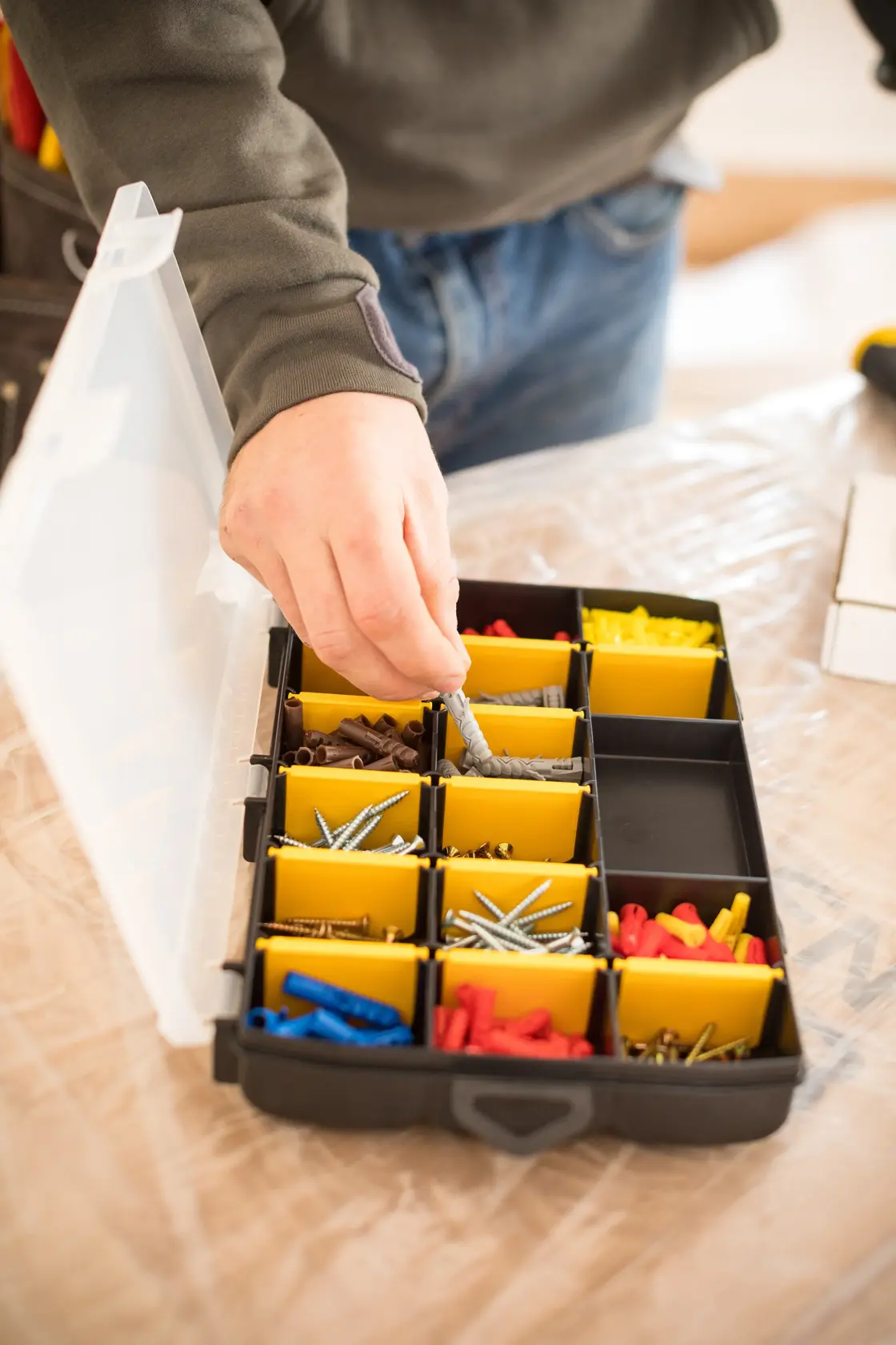 STANLEY STST81680-1 organizer box with yellow compartments, assorted screws and plugs, top view.